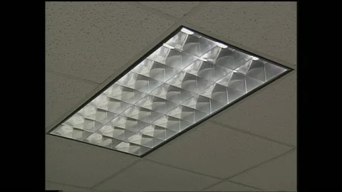 1990s: Hand flips light switch, ceiling panel of fluorescent tube lights Video stock 145168117