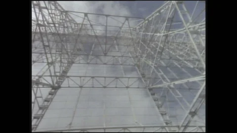 1990s: Looking up at large satellite dish array structure on ground. Woman and Stock Footage 146555209