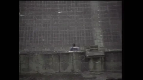 1990s: Low angle of satellite dish. Man on satellite dish, zoom out. Aerial Vidéo 136854248