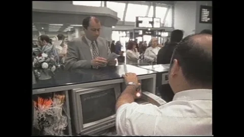 1990s: Man checks in for flight.  Planes move across runway.  Busy airport 스톡 동영상 120487399