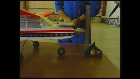 1990s: Man measuring parts of model plane. Hands measure wheels of model. Tilt Stock Footage 113989023