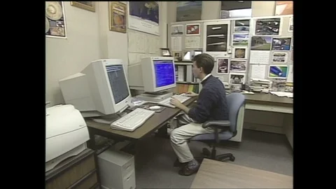 1990s: Man sits in front of computer in office. Man typing on computer. Man Stock Footage