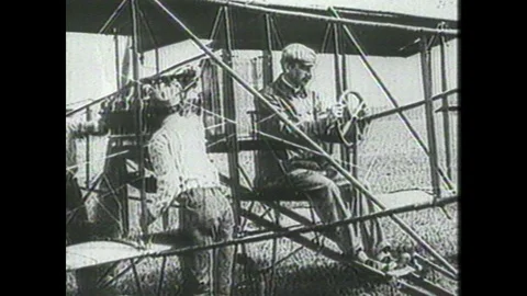 1990s: Men wind propeller on experimental aircraft. Wright Brothers plane rolls Stock Footage 104267873