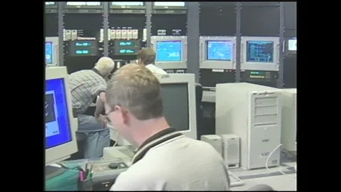 1990s: Men work at computers in wind tunnel control room. Model aircraft glows Stock Footage 120487587