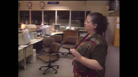 1990s: Office.  Woman points to computer screen and speaks.  Man answers phone. Stock Footage 128452553