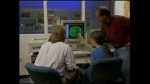 1990s: People around computer, zoom in on screen. Animation of wave traveling on Stock Footage 113989246
