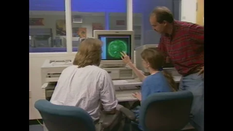 1990s: People gather around computer screen, look at screen, talk. Timeline Stock Footage 105381311