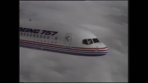 1990s: Pilots maneuver knobs in plane cockpit. Boeing 757 soars amidst sky and 스톡 동영상 145548124