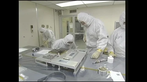 1990s: Scientists in clean suits work on experiment cases in laboratory. Stock Footage 120488522