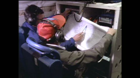 1990s: Scientists operate computers and consult map onboard research plane. Stock Footage 146671928