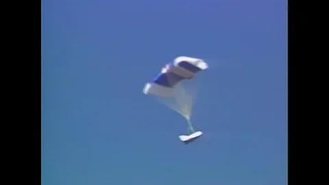 1990s: A space shuttle falls across the sky with its parachute deployed.  A Stock Footage 74735277