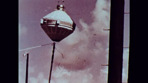 1990s: Two men lower spacecraft model on wire. Man adjusts knobs on monitoring 스톡 동영상 127731647