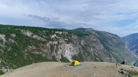 2 in 1 video The man stand near the tent on the background of mountain landscape Stock Footage 77875935