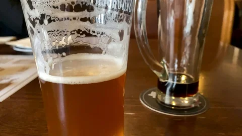 2 almost empty glasses of beer Stock Footage 122360601
