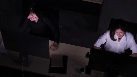 2 Asian customer service call centers working late, stretching arms. Stock Footage 170418878