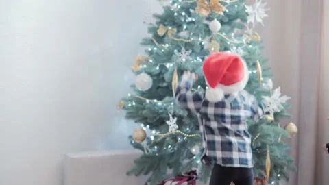 2 authentic happy Joy children wave hands hello rejoice by Christmas tree play Stock Footage 153728500