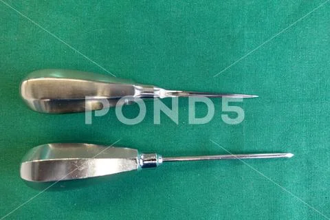 2 awls of different sizes lie on a green surgical drape Stock Photo ...