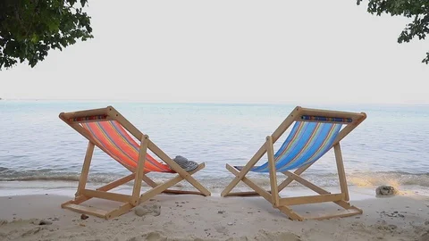 The 2 beach chairs is on the sand beach with sea in background. Stock Footage 103950169