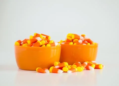 2 bowls of candy corn with overflow isolated on white Stock Photos