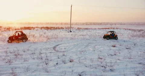 2 buggies ride against the sunset in winter Stock Footage 105869174