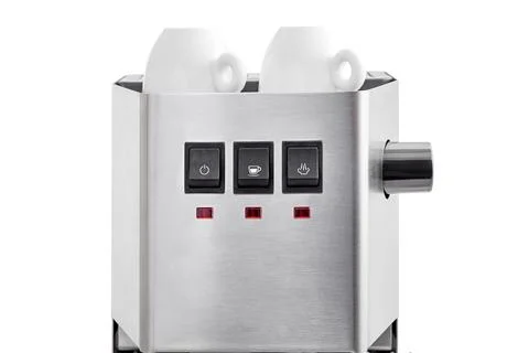 2 ceramic white espresso cups stand on warming top of a coffee machine. Stock Photos