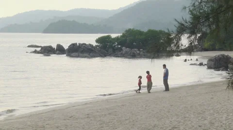 2 children playing at beach with parent watching Stock Footage 33718230