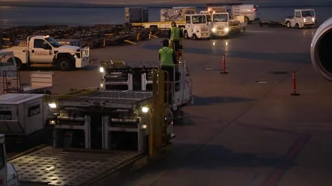 (2 Clips) Cargo Loader Tractor Driving to Airplane to Unload Commercial Cargo Video stock 219373182