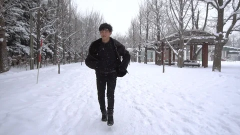 2 Clips - Slowmo - Happy Young Asian Man Running in Winter - Front Tracking Shot Stock Footage 101054566