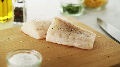 2 Cod fillets on a wooden board. Slight camera slide Stock Footage 92147616