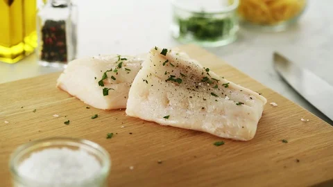 2 Cod fillets on a wooden board. Slight camera slide Stock Footage 92147641