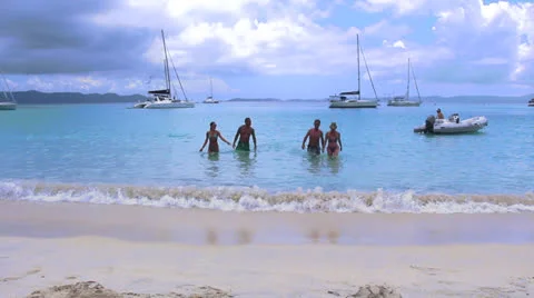 2 Couples walking out of the surf onto the Beach Stock Footage 26733873