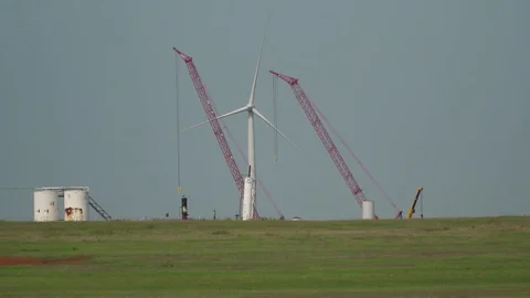 2 Cranes build Wind farm on the Oklahoma prairie 動画素材 79807057