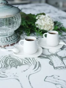 2 cups of coffee on the table, thuja twigs, white flower Stock Photos