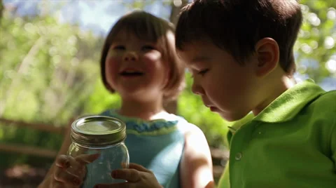 2 Curious Children Look In Jar At Bug, Enjoy Nature Together Stock-Footage 38424136