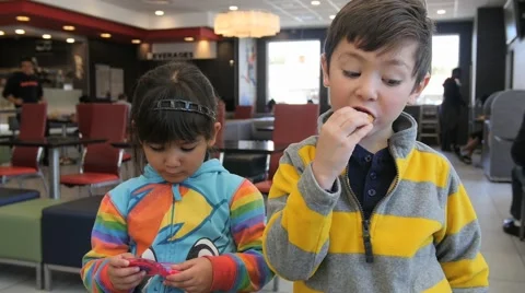 2 CUTE HISPANIC SIBLINGS EAT IN FAST FOOD RESTAURANT. Stock-Footage 63319615