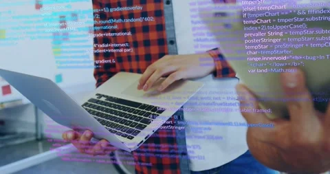 2 devs working tech holding laptop tapping pad other entering swiping tablet Stock Footage 331820818