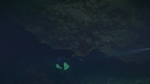 2 divers from behind enter in a crack on the seabed, Ustica, Mediterranean sea Stock-Footage 125105111