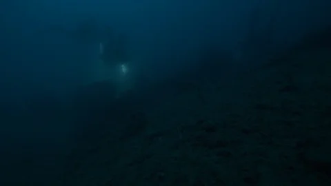 2 divers with torch swims at the rocky seabed,Argentario,Mediterranean sea,Italy Stock Footage 108742551