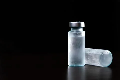 2 doses of Sars-Kov-2 coronavirus vaccine in transparent glass ampoules, cove Stock Photos