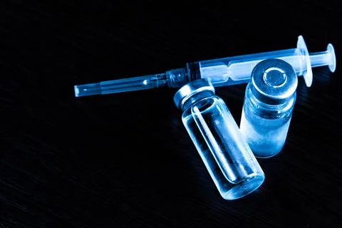 2 doses of Sars-Kov-2 coronavirus vaccine in transparent glass ampoules, cove Stock Photos