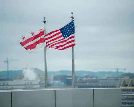 2 flags flying with plain background. Washington, DC flag and the American fl Stock Photos