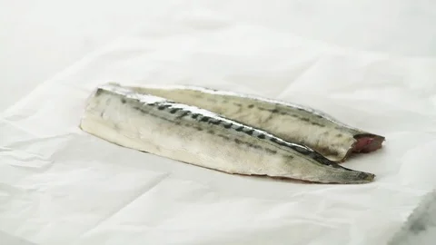 2 fresh Mackerel fillets on grease-proof paper on marble. Slight camera slide an Stock Footage 92145147