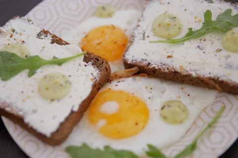 2 fried eggs with bread, cheese, and salad greens Stock Photos