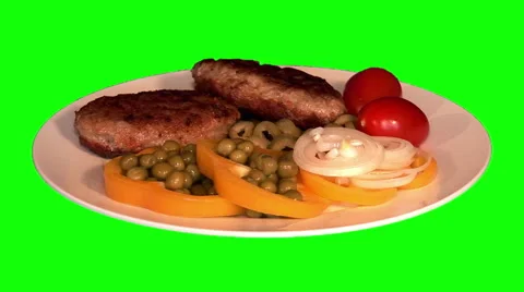 2 fried pork chops with raw vegetables on plate Stock Footage 47543864
