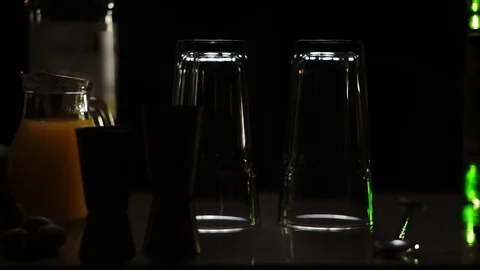 2 glasses stand on the table between bottles with syrup Stock Footage 93970583