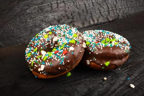 2 glazed chocolate donuts sprinkled on a dark background. sweet tasty bun Stock Illustration