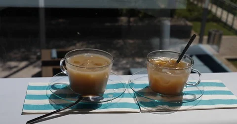 2 Iced Coffees on a table with exterior views. Different angles Stock Footage 100039436