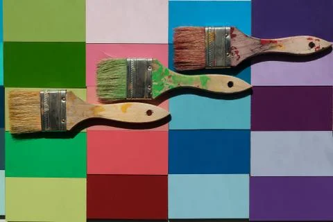 2 Inch paint brushes horizontal on a bright colored tiled background Stock Photos