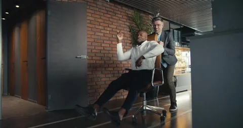 2 men fool around and have fun at work. Happy time at work in the company of Stock Footage 243453496