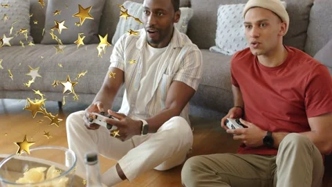 2 men sitting on floor gaming starting using white pads competing golden stars Stock Footage 333494244